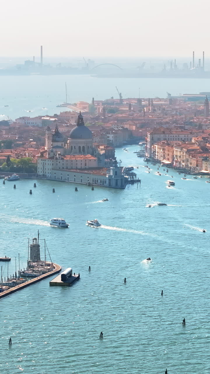 Luftdronebillede af både, der bevæger sig gennem Venedig, Italien, på en solskinsdag. Lodret