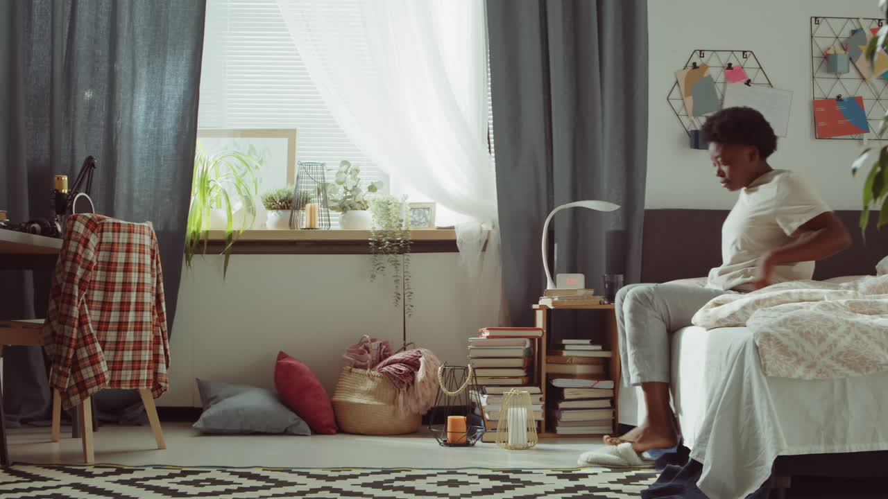 아프리카계 미국인 여성 이 아침 에 침대 에서 일어나고 있다