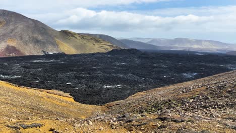 Riesiges-Lavafeld-In-Island-Zwischen-Bergen,-Schwenkansicht-Von-Rechts