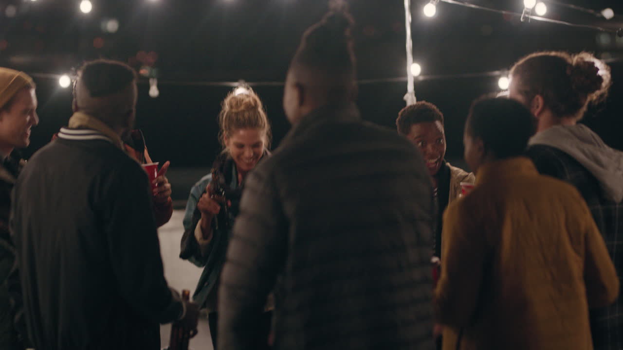 feliz fiesta en la azotea amigos bailando divirtiéndose socializando juntos disfrutando de la celebración de la reunión charlando compartiendo bebidas celebrando la amistad reuniéndose en la azotea por la noche