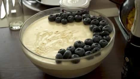 close up of delicious cheesecake with blueberries on top served with champagne and a sparkling wine bottle in a kitchen