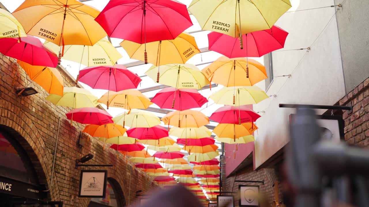 Warm and colorful umbrellas on Camden Market’s ceiling in London, create a vibrant attraction for tourists