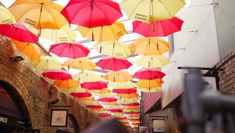 warm and colorful umbrellas on camden market’s ceiling in london, create a vibrant attraction for tourists