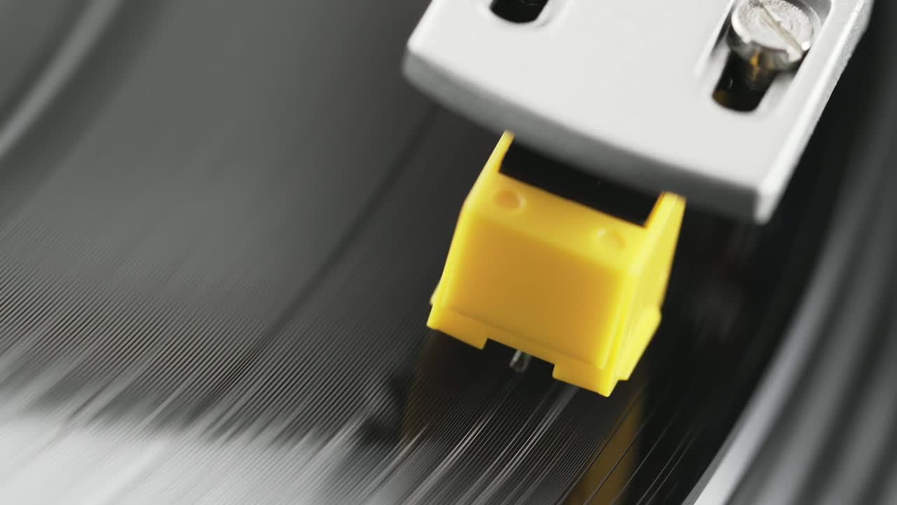 비닐 플레이어 턴테이블: 회전하는 비닐 레코드의 조각, 바늘을 클로즈업으로 가진 스타일러스, 바늘과 비닐 판을 클로스업으로 멈추는.