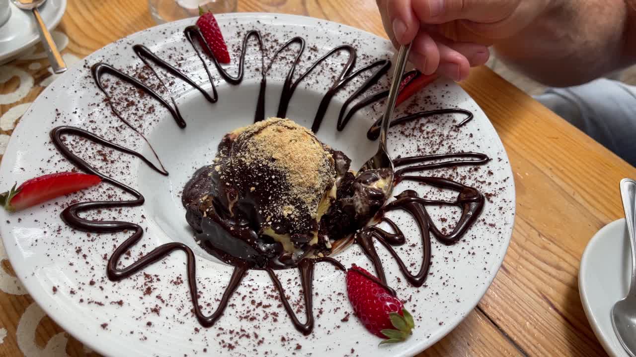 Spoon taking bite of chocolate brownie ice cream ball