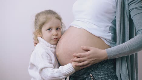 Hübsches-Mädchen-Streichelt-Schwangere-Mutter-Mit-Großem-Bauch-Im-Zimmer