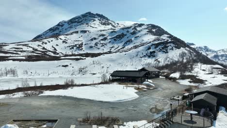 Casas-Rurales-En-Alquiler-En-La-Cima-De-La-Montaña-Sognefjellet-En-Noruega---Antena-De-Verano-Con-Nieve-Todavía-En-El-Paisaje