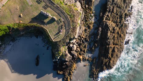 Vista-Aérea-De-Las-Olas-Del-Mar-Rompiendo-En-La-Costa-Rocosa-De-La-Playa-En-Verano-En-Caion,-Galicia,-España