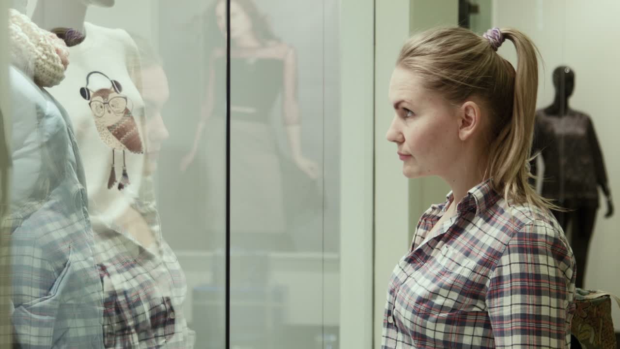The Girl Looks At a Show-window Of Clothing Store