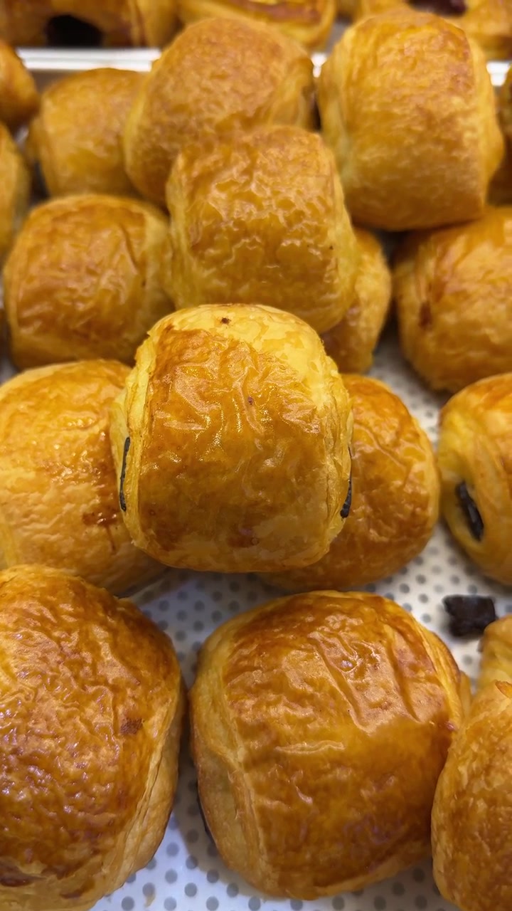 Cornetti al cioccolato appena sfornati su un vassoio da pasticceria