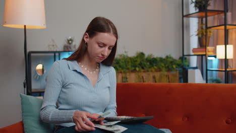 chica rica feliz contando dinero en efectivo y el uso de la calculadora, calcular los ingresos domésticos ganancias en el hogar