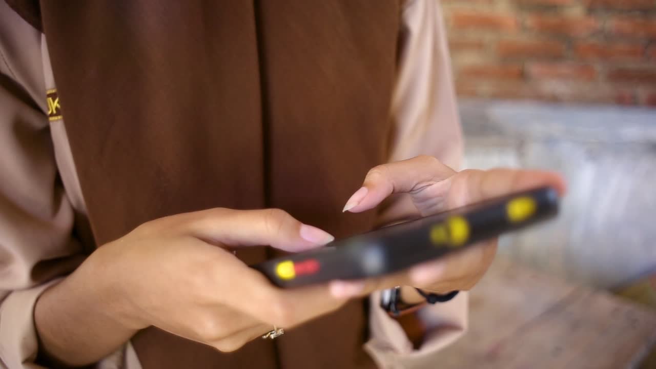 Close up of young hand girl in trendy look typing an sms message while sit down, Lifestyle Communication Technology Concept, woman’s hands holding cellphone