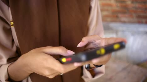 close up of young hand girl in trendy look typing an sms message while sit down, lifestyle communication technology concept, woman’s hands holding cellphone