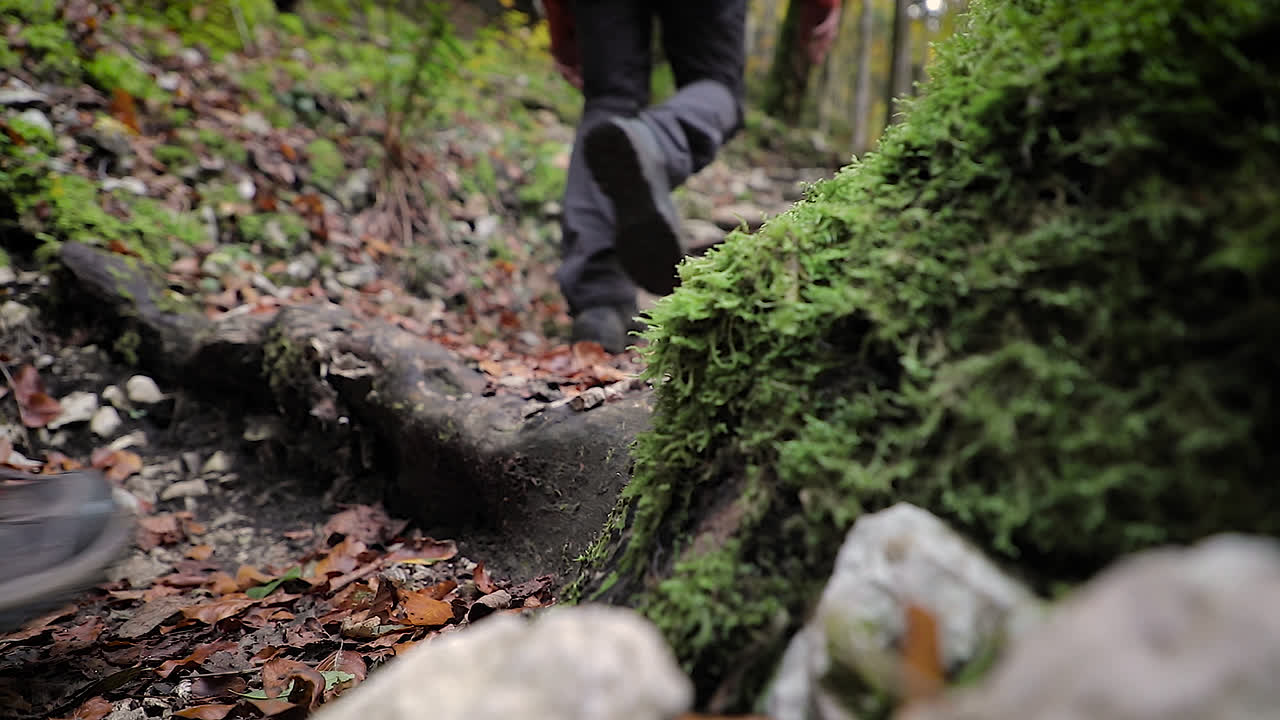 toma de tierra baja de dos excursionistas caminando por senderos al aire libre, vista de pies y piernas solamente
