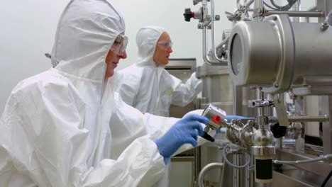 scientists in protective suits working together