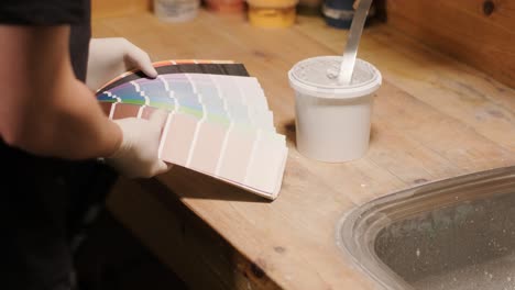 a worker examines a palette of colors to select a paint