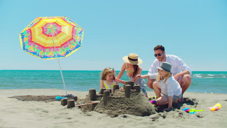 family building sandcastles on the beach