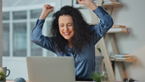 joyful manager celebrating achievement at desk. closeup excited professional