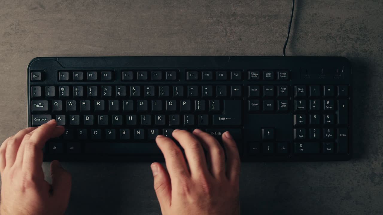 Hands typing on a black keyboard