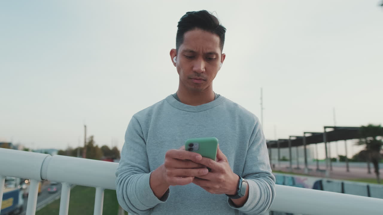 밖에서 스마트폰을 사용하는 남자