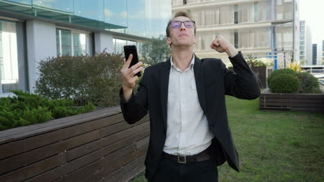 hombre recibiendo noticias por teléfono, saludando, celebrando el éxito