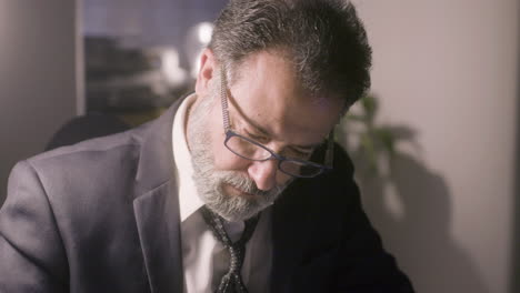 closeup shot of middle-aged grey-haired man in glasses