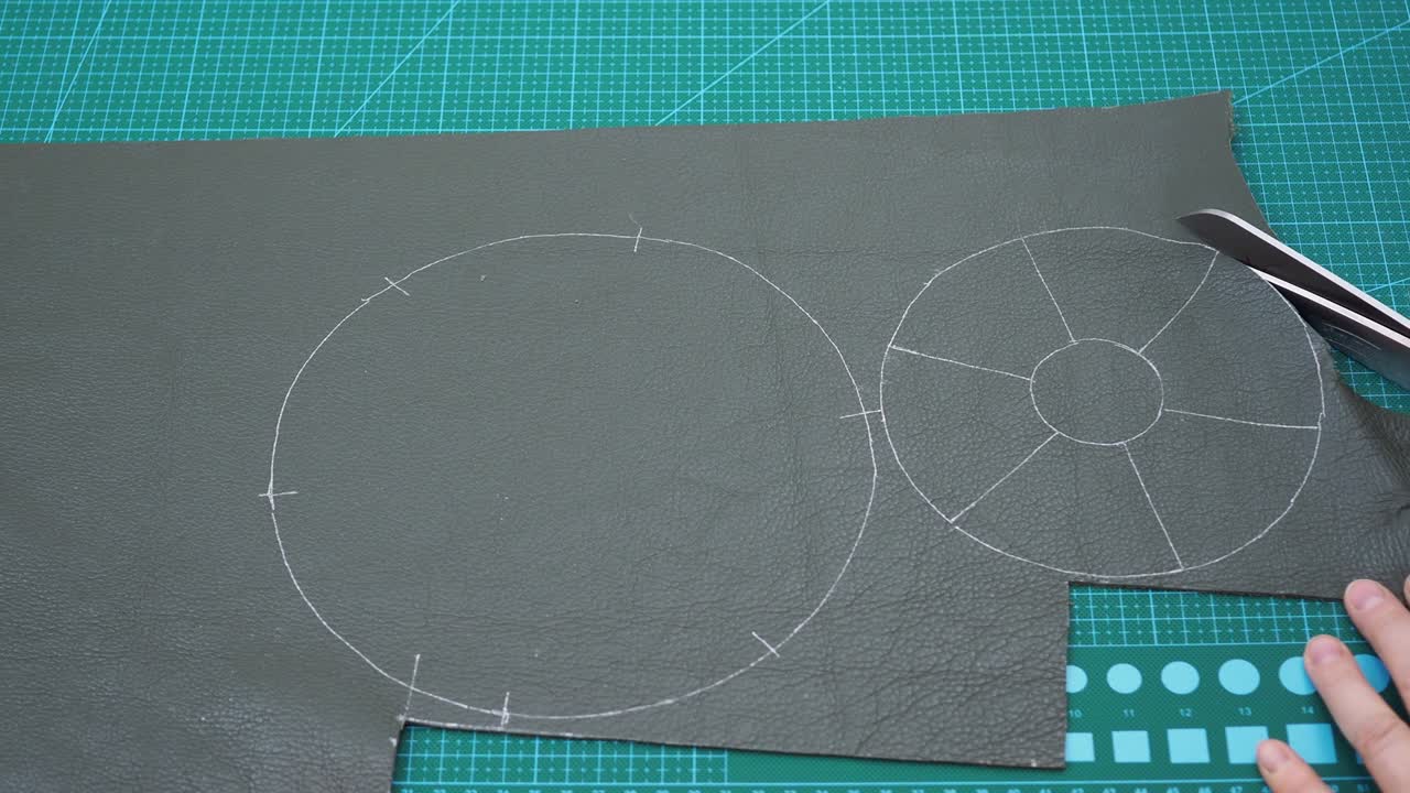 장인 은 가죽 으로 가방 의 세부 사항 을 가위 로 잘라 낸다