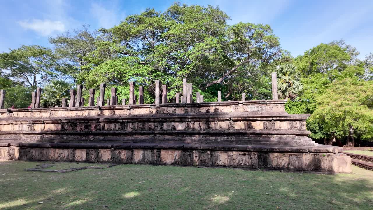 Explore the historical ruins of the ancient council chamber set amidst lush greenery in Polonnaruwa, Sri Lanka, showcasing architectural heritage.