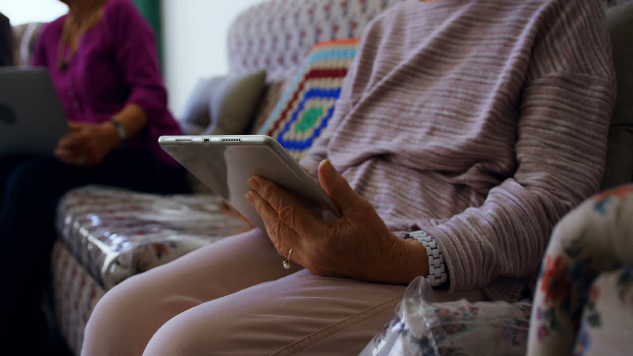 Mid section of active senior woman using digital tablet at nursing home 4k