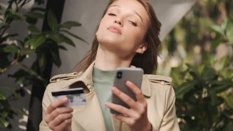 estudiante caucásica haciendo compras en línea en el teléfono inteligente al aire libre.