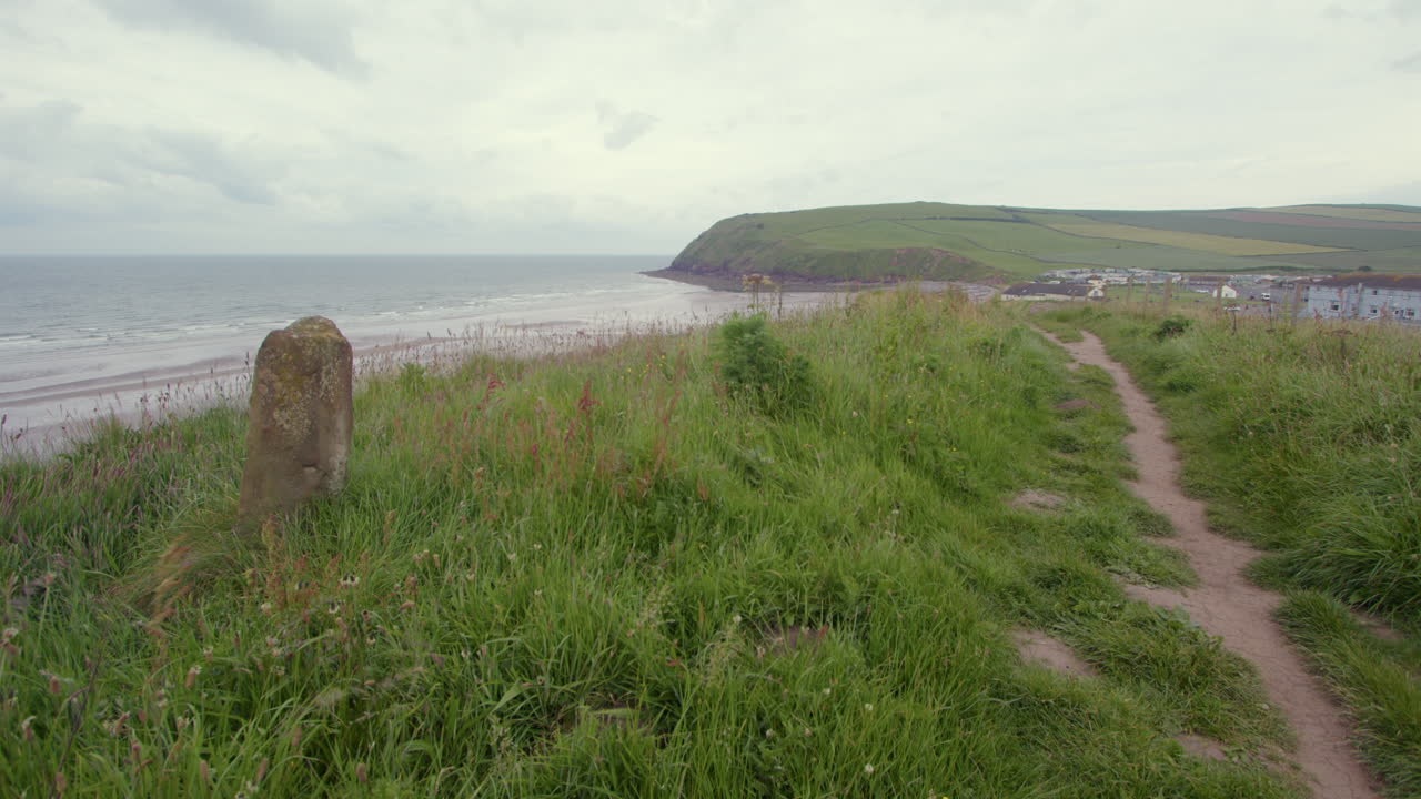 extra wide Shot of the sea, beach, headland at st bees with stone marker in foreground. West lake district