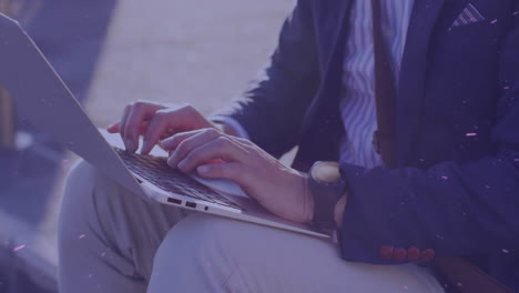 typing on laptop outdoors, person in business attire with animation effects
