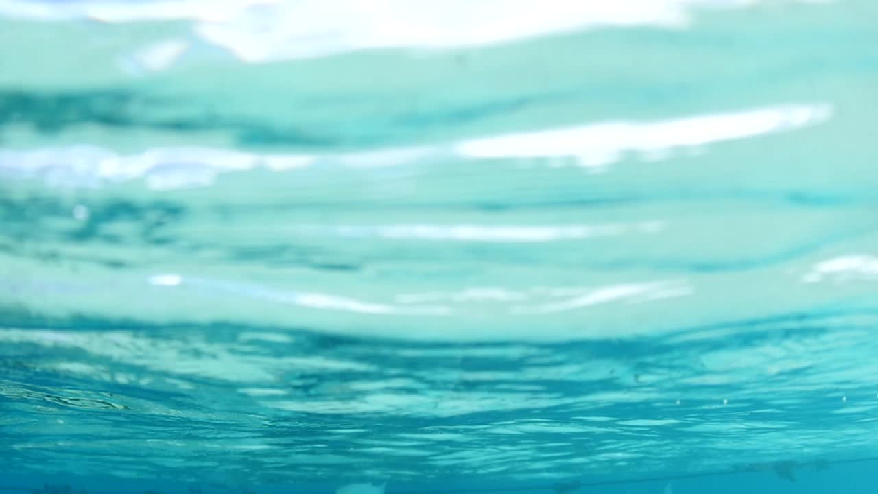 Underwater slowmotion shot, clear water reflection. Location Moorea ...