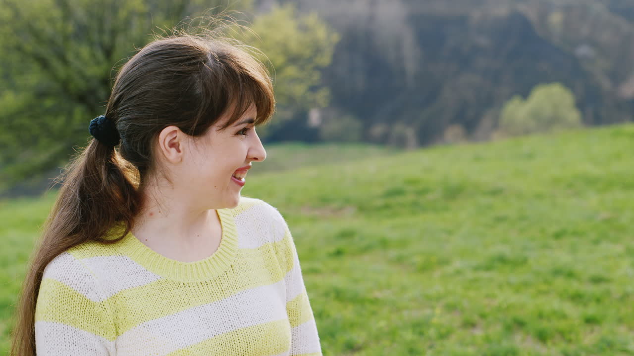 푸른 잔디밭에서 아이를 안고 있는 귀여운 젊은 여성