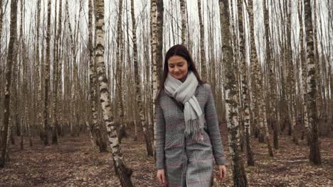 Mujer-Joven-Va-A-Través-De-Los-árboles-A-La-Cámara-En-El-Bosque