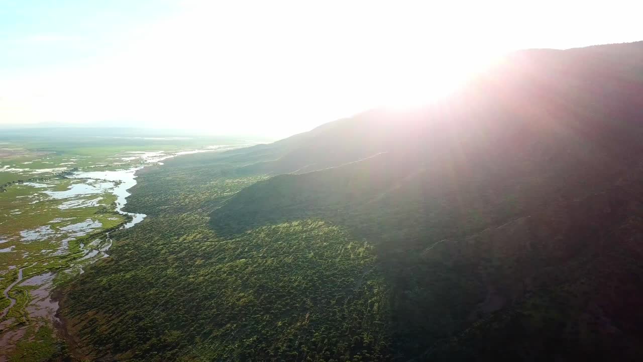 Bright Sun Over The Mountain Next To Lake Natron, Alkaline Lake In Ngorongoro, Arusha, Tanzania. aerial pan left