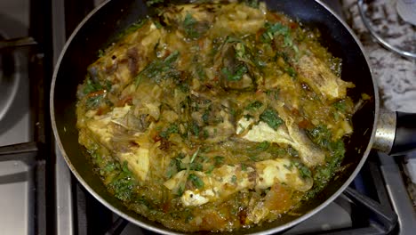 overhead view of fish curry being fried in