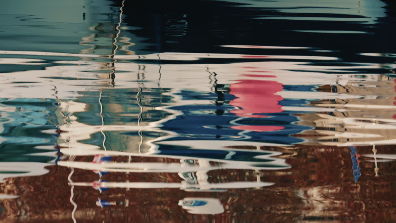 Close up view of moored boats reflected on calm marina water