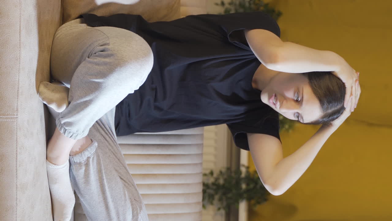 머리에 손을  ⁇ 고 절망적인 젊은 여성의 수직 비디오. 우울합니다.