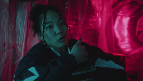 cool looking asian woman vibing to music on retro cassette player