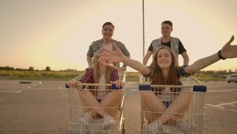 young friends having fun on a shopping carts. multiethnic young people playing with shopping cart