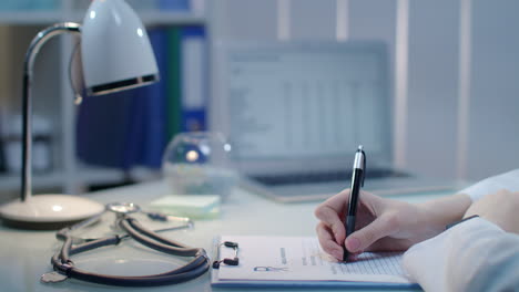 woman doctor hand writing document at medical workplace. clinic health care