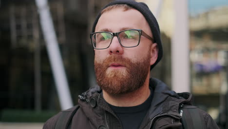 close-up portrait of a bearded man with glasses and a beanie