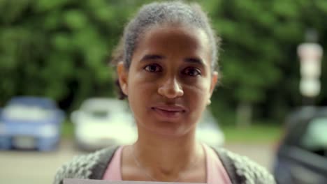 Attractive-Black-Woman-holds-"Stop-Racism"-Protest-Poster-in-front-of-her-Face