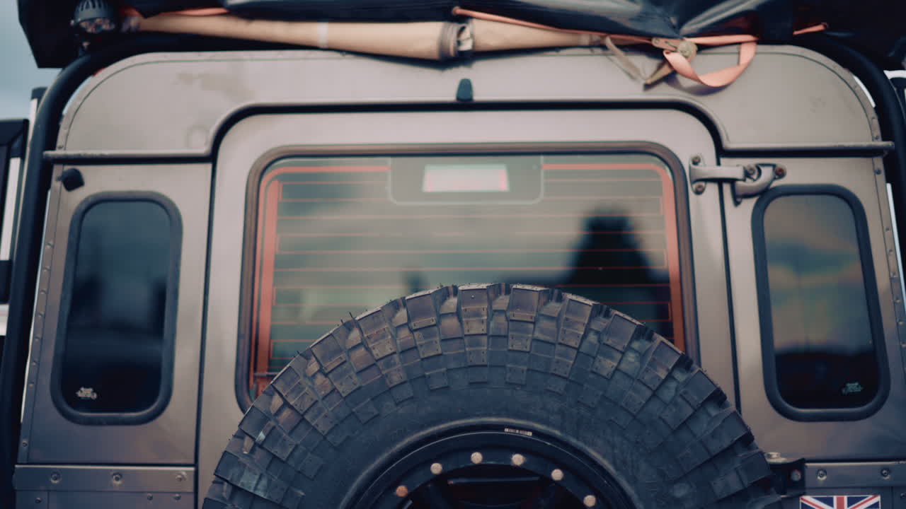 Back view of an off road vehicle equipped with spare tire and roof tent