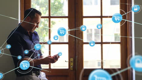 Using-smartphone,-man-connected-to-shopping-and-security-icons-by-window