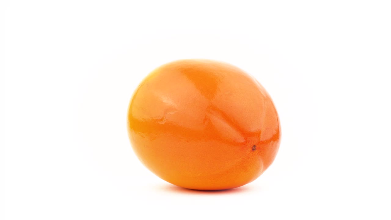 una fruta de caqui de caqui. girando en la mesa giratoria. aislado en el fondo blanco. primer plano. macro.