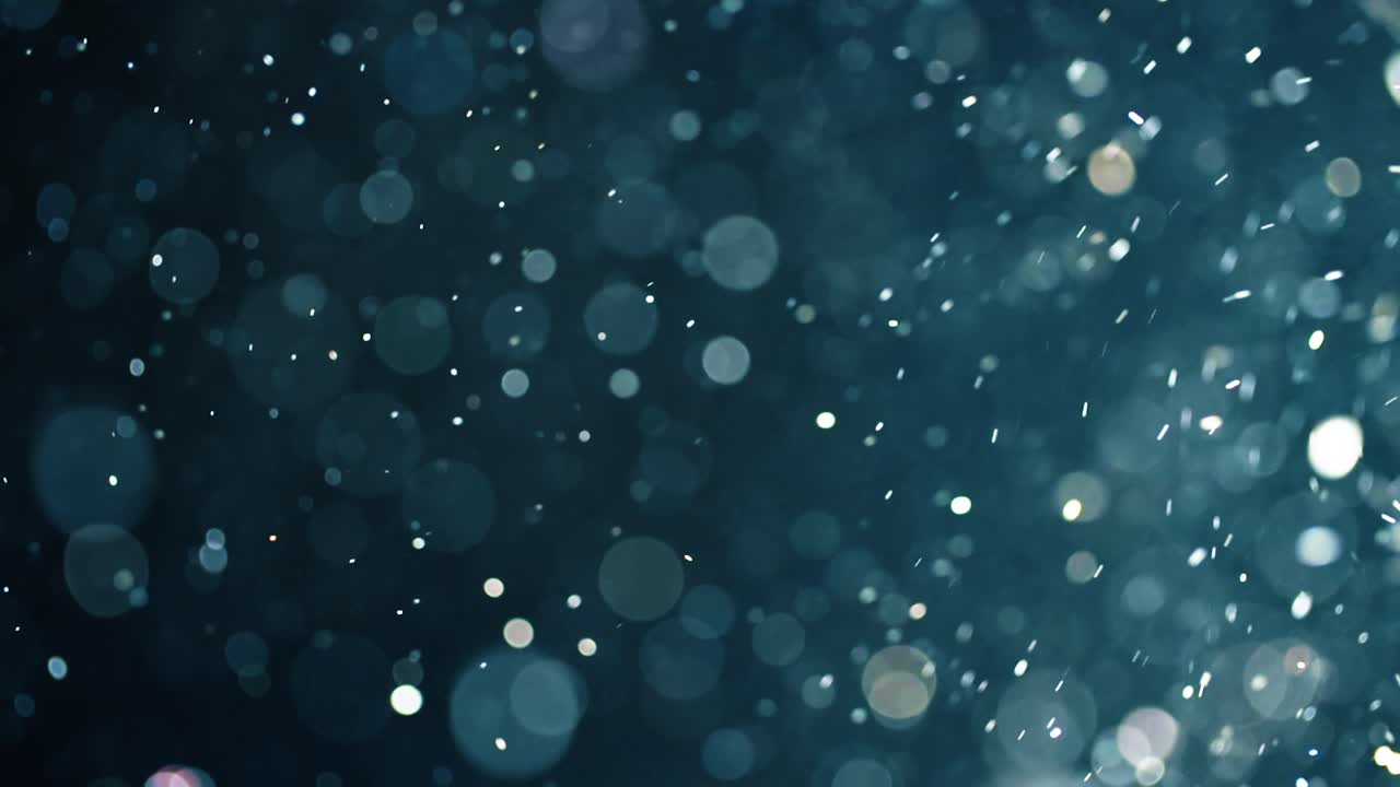 Floating abstract particle bokeh on dark background