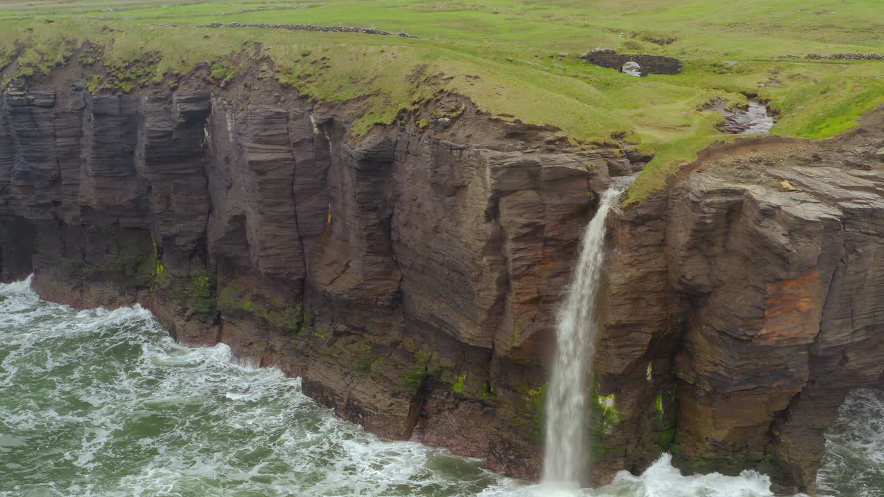 Aerial ascend showcasing iconic waterfall and stone bridge at Doolin cliff walks
