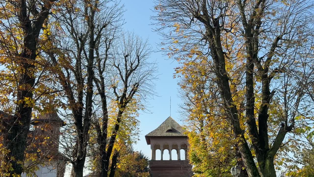 autumn trees framing the arched tower entrance of Mogoșoaia Palace